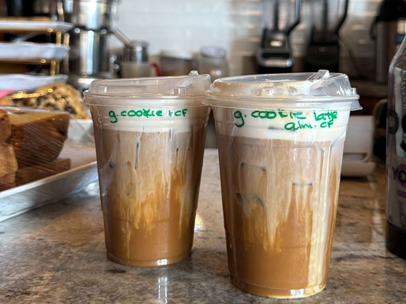 Cups on the counter with the order written on the lid