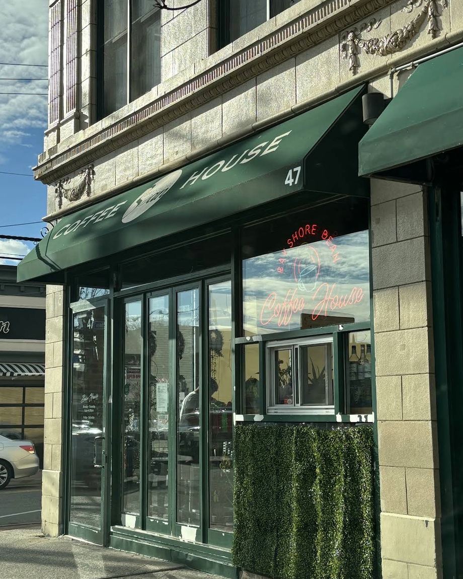 The green awning and neon sign at 47 East Main Street